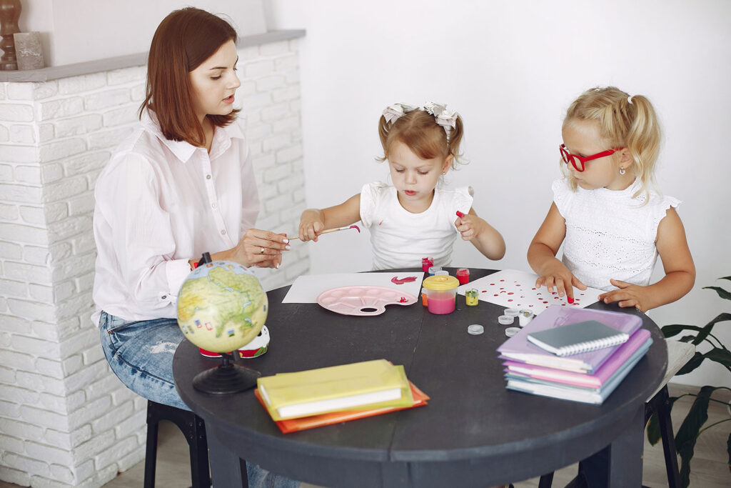 tutor-with-two-little-girls-studying-at-home-2023-11-27-05-36-18-utc